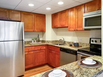 A kitchen with wooden cabinets and granite countertops.